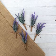 three lavender flowers tied with twine on burlap