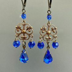 "Beautiful Brass Filigree with Vintage inspired Sapphire Faceted Glass Jewel Teardrops  and Sapphire Blue Czech Crystals to add sparkle.  Antiqued Brass Leverback Earwires Measure just under 2.5\" from top of earwire to bottom of teardrop" Ornate Teardrop Chandelier Earrings Nickel Free, Ornate Blue Dangle Earrings, Blue Ornate Dangle Earrings, Blue Ornate Handmade Earrings, Ornate Handmade Blue Earrings, Handmade Blue Ornate Earrings, Blue Metal Chandelier Earrings For Pierced Ears, Vintage Blue Dangle Earrings, Ornate Blue Pierced Earrings