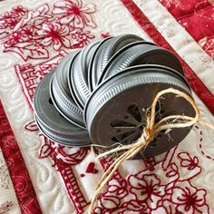 some tins sitting on top of a red and white quilted table cloth with twine