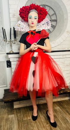 a woman in a red and white dress holding a heart