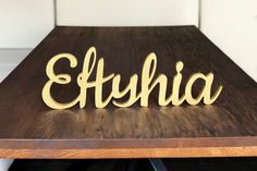 a wooden table with the word etuhia carved into it's wood letters