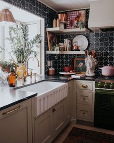 a kitchen with black and white tiles on the walls, counter tops, and cabinets