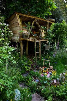 a small wooden structure surrounded by plants and flowers