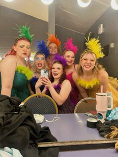 a group of women taking a selfie in front of a mirror at a party