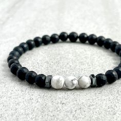 Men's beaded bracelet made with strong, stretchy cord and genuine/natural gemstones. Features ~ 6mm Faceted Matte Onyx beads ~ 6mm Faceted White Howlite beads ~ 6mm hexagonal Hematite beads ~ Stretchy cord; simply slide bracelet on and off wrist ~ Comes packaged in a reusable microfibre pouch To ensure the perfect fit, please use the bracelet sizing instructions found in the photo gallery. Onyx - A powerful protection stone, Black Onyx absorbs and transforms negative energy, and helps to prevent Slide Bracelet, White Howlite, Protection Stones, Mens Beaded Bracelets, Hematite Beads, Onyx Bead, Beaded Stretch Bracelet, Bead Bracelet, Stretch Bracelet