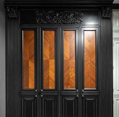 a black door with wood paneling on the side