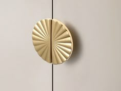 a close up of a door handle on a white cabinet with a gold ring in the middle