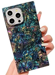 a woman holding up an iphone case with blue and green marble pattern on the back