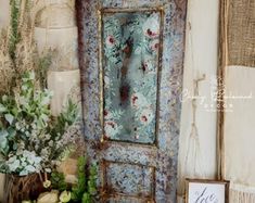 an old door is decorated with flowers and greenery