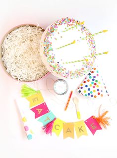 a birthday party with confetti, streamers and cake decorating supplies on a white background