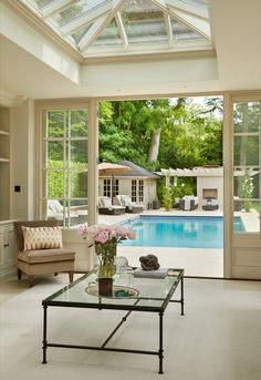 a living room filled with furniture next to a swimming pool