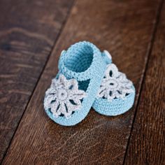 a pair of crocheted baby shoes sitting on top of a wooden floor with the words, shop ready to wear items