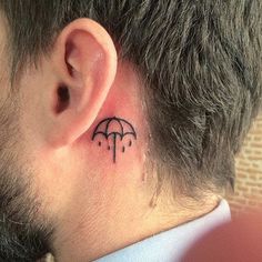 a man's ear with an umbrella tattoo on it