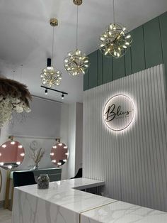 a salon with white counter tops and chandeliers hanging from the ceiling above it