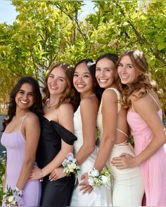 a group of women standing next to each other in formal wear posing for the camera