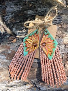 the earrings are made out of copper and turquoise colored sticks with an intricate design on them