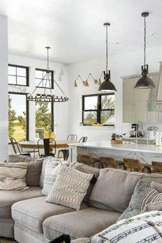 a living room filled with furniture next to a kitchen and an island in the background