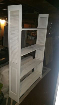 a white shelf with shutters on it