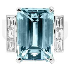 18 Karat White Gold 11.01 Carat Aquamarine Emerald-Cut Statement Cocktail Ring This marvelous cascading blue aquamarine and diamond ring is a statement piece. The solitaire long emerald cut aquamarine in grain prong setting is brilliantly combined with three identical matching princess square diamonds on either side in a bezel setting, to accentuate the center aquamarine. The heightened white gold shank holding the stones from the sides and the graduating solid gold band add profundity to this c Aquamarine Cocktail Ring, Solid Gold Band, Aquamarine Engagement Ring, Family Jewellery, White Gold Diamond Rings, Aquamarine Stone, Square Diamond, Aquamarine Rings, Handmade Rings