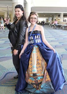 two women standing next to each other in dresses