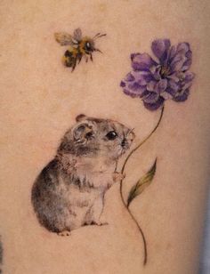 a hamster and a bee on the back of a woman's leg with flowers