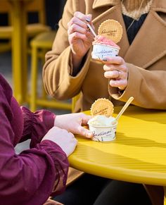 two people sitting at a table eating ice cream