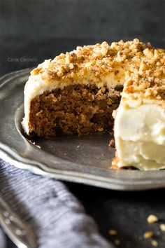 a cake with white frosting and crumbs is on a plate next to a fork