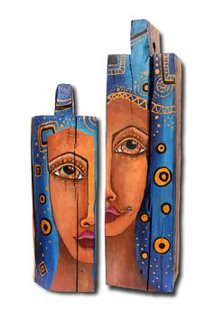 two pieces of art made out of wood with faces painted on the sides and in different colors