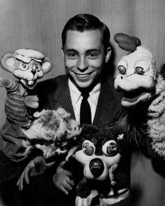 a man holding three stuffed animals in his hands