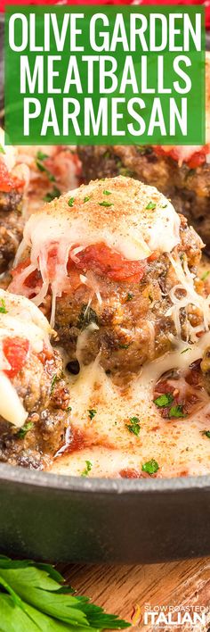 a skillet filled with meatballs covered in cheese and tomato sauce on top of a wooden table