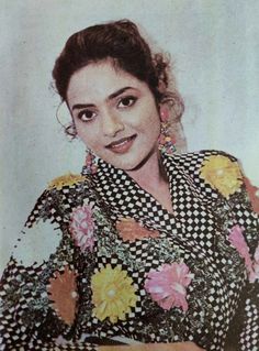 an old photo of a woman with flowers on her shirt and hair in a bun