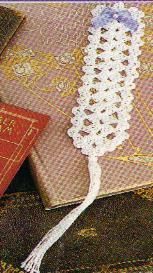 a cross stitch bookmark with a crochet tassel on top of it