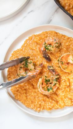 a white plate topped with shrimp and grits