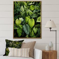 a living room with a white couch and green plants in the frame on the wall