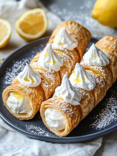 three croissants on a plate with whipped cream and lemon slices in the background