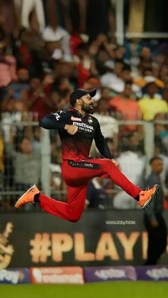 a man is jumping in the air with his feet up and arms out to catch a ball