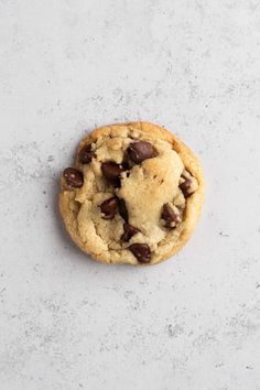 a chocolate chip cookie sitting on top of a white counter