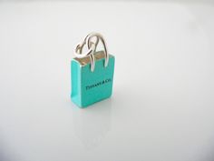 Overview: Here is a gift that she will surely adore! It is THE classic Tiffany piece - super pretty, stylish, and very versatile! This "Shopping Bag" will make someone REALLY happy! :) Offered for sale is a wonderful Tiffany & Co. Sterling Silver & "Tiffany" Blue enamel Shopping Bag charm. I am 100% sure that this is one charm that will be used a lot! Great conversation piece as well - in case you run out of small talk at a cocktail party. The item is a wonderful piece that is perfect fo Rare Gifts, Tiffany Jewelry, Small Talk, Gift Love, Jewelry Style, Tiffany Blue, Style Accessories, Design Fashion, Silver Blue