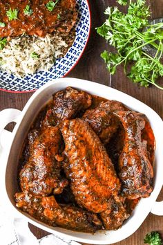 two bowls filled with meat and rice next to some parsley on the side,