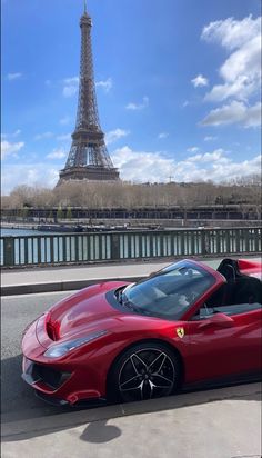 a red sports car parked in front of the eiffel tower