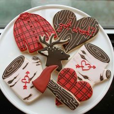 decorated cookies are arranged on a plate in the shape of heart, deer and hearts