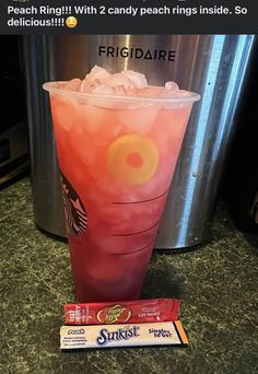 a pink drink sitting on top of a counter next to some candy