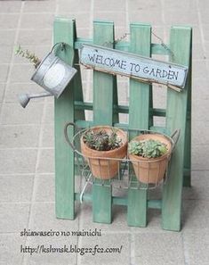 a welcome to garden sign sitting on top of a wooden chair with potted plants