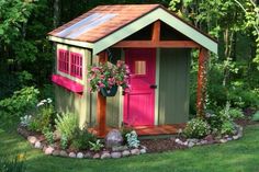 a small garden shed with pink doors and windows