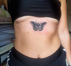 a woman's stomach with a butterfly tattoo on her belly and the bottom part of her abdomen