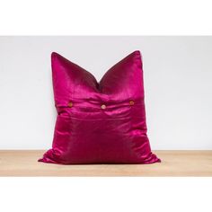 a pink pillow sitting on top of a wooden table