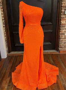 Radiate with unparalleled beauty in this orange mermaid gown. Embracing a tantalizing mermaid silhouette, this one-shoulder creation is adorned with brilliant orange sequins that catch the light perfectly. Its long sleeves add a touch of timeless elegance, while the lace-up back offers a hint of sultriness. The captivating slit on the skirt ensures you move with grace and confidence, embodying pure elegance. Orange Prom Dresses, Split Prom Dresses, Orange Long Sleeve, Sequin Sleeve, Prom Dresses Blue, Stretch Satin, Mermaid Prom Dresses, Long Prom Dress, Dress Details