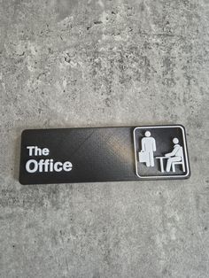 a sign on the ground that says the office with a person sitting at a desk