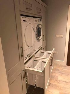 a washer and dryer in a room with wood flooring on the ground