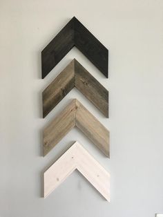 five different colored wood planks arranged in the shape of an arrow on a wall